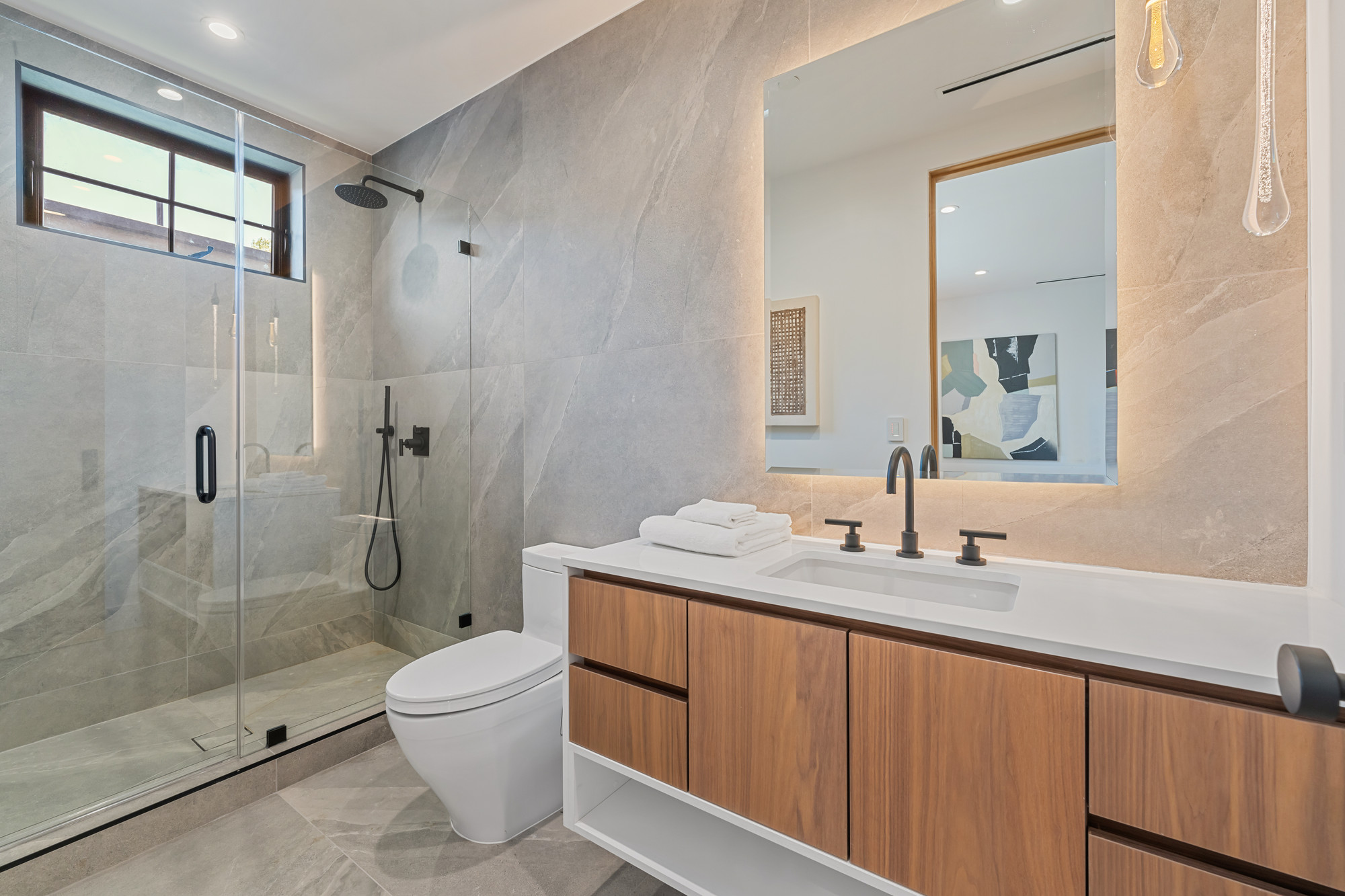 Walnut floating vanity with honed stone